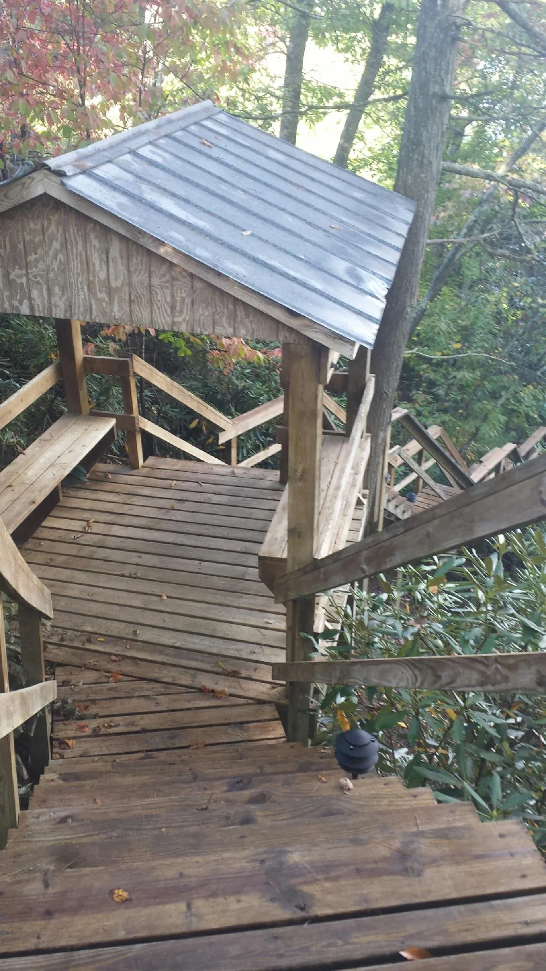Metal roofed shelter over wooden steps on a wooded walkway — Skylight Repair & Installation work by our crew in Camden